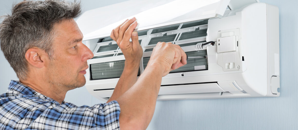 Portrait Of Mid-adult Male Technician Repairing Air Conditioner